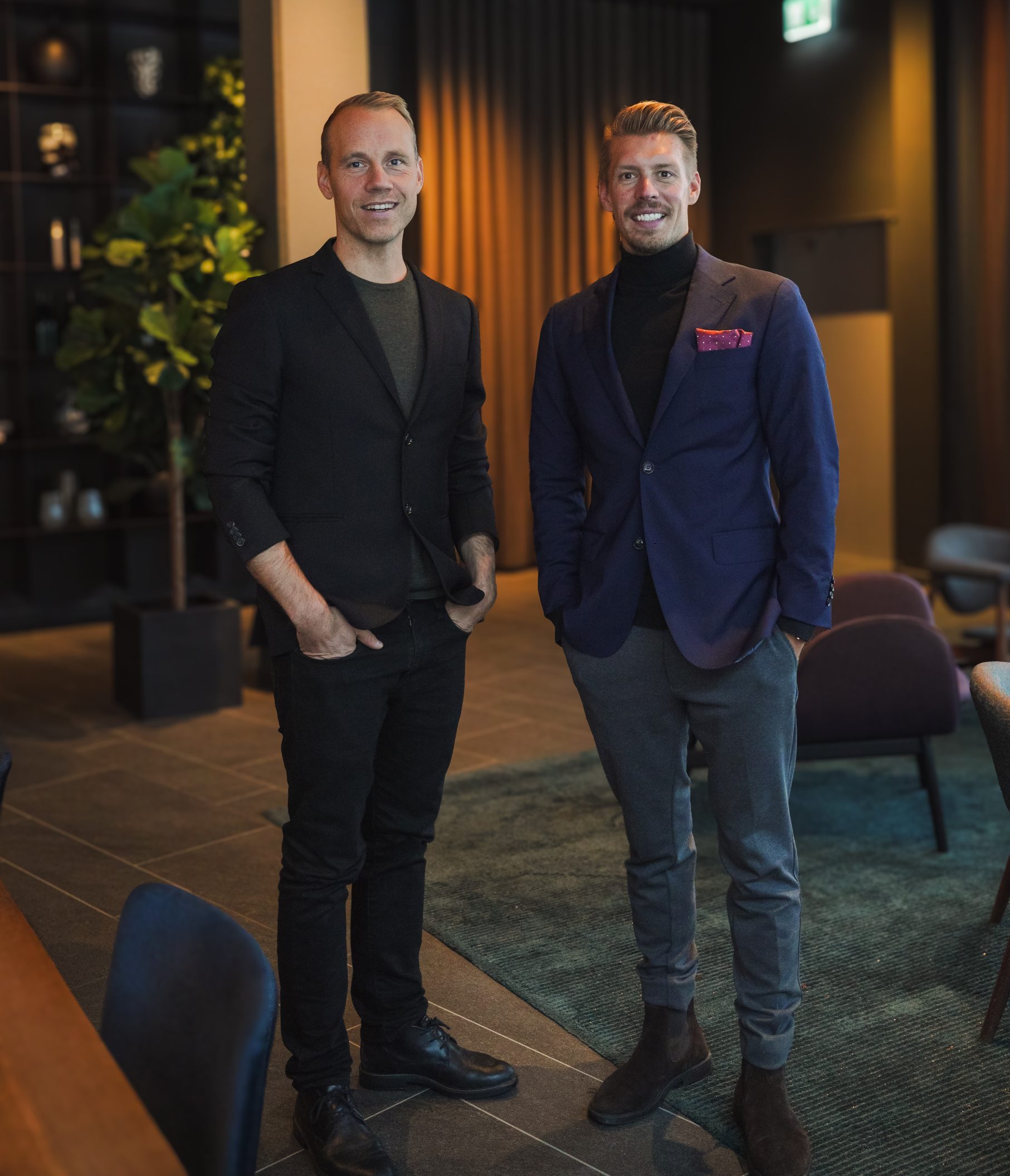 Erik Jonsson och Mattias Matsson, grundare av Visionite, står klädda i kostym och ler in i kameran