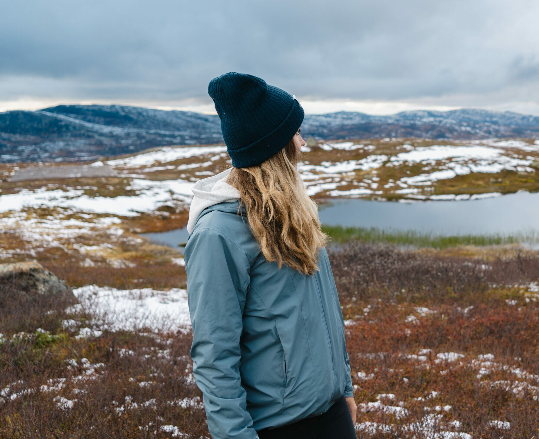 Kvinna står och tittar ut över fjället