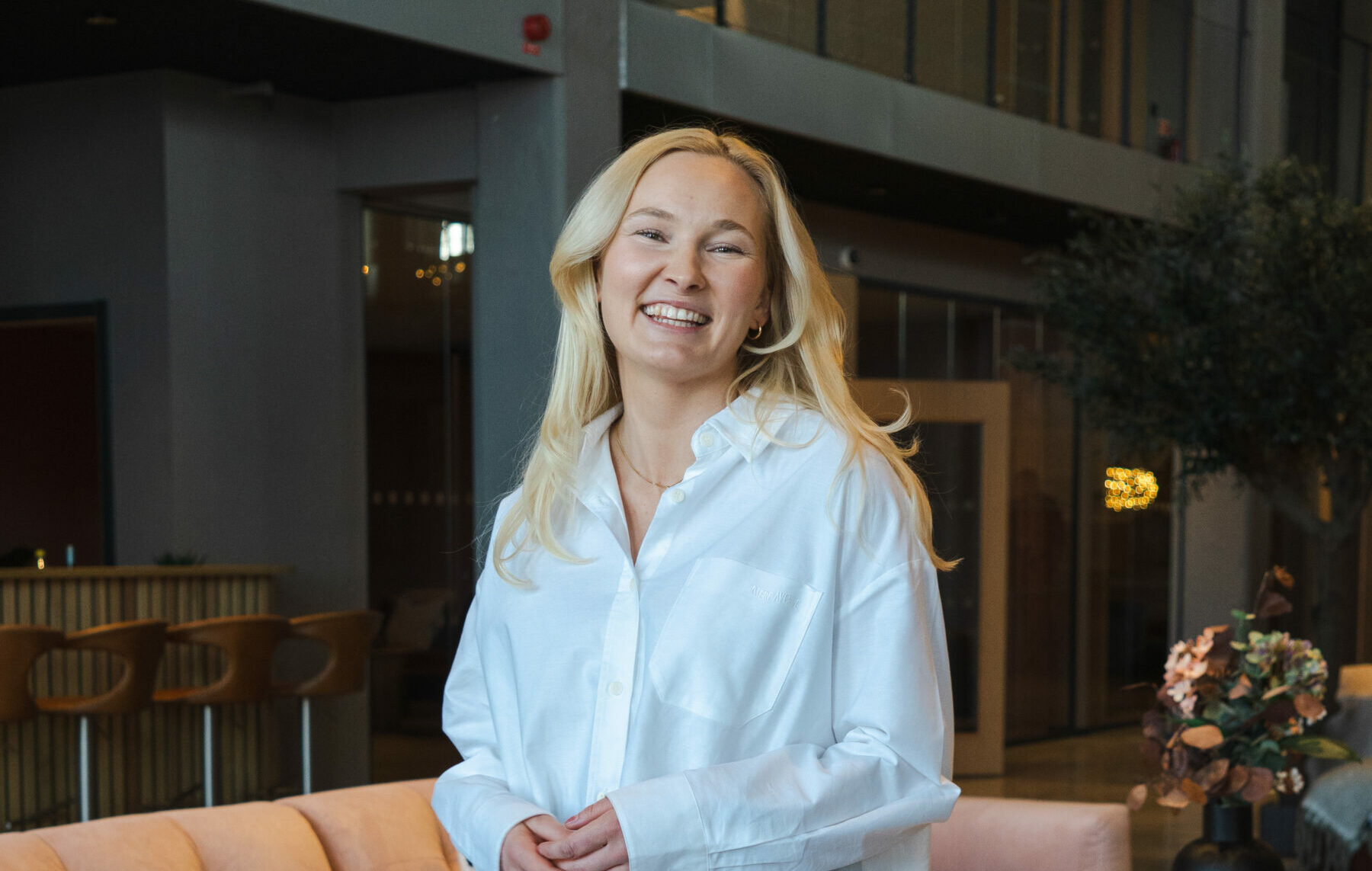Porträtt på Julia Eriksson Helldén som är lokal VD för Visionite i Falun Borlänge. Hon står i en mysig kontorsmiljö och ler mot kameran.