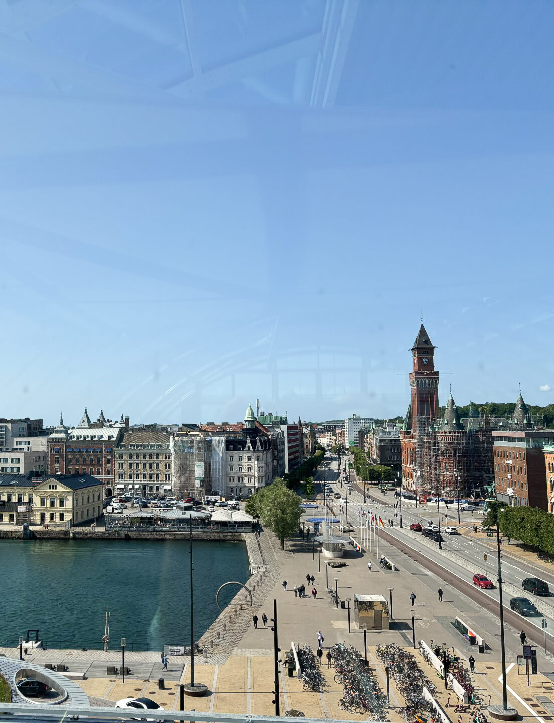 vy över vatten, bro med körande bilar och hus på andra sidan