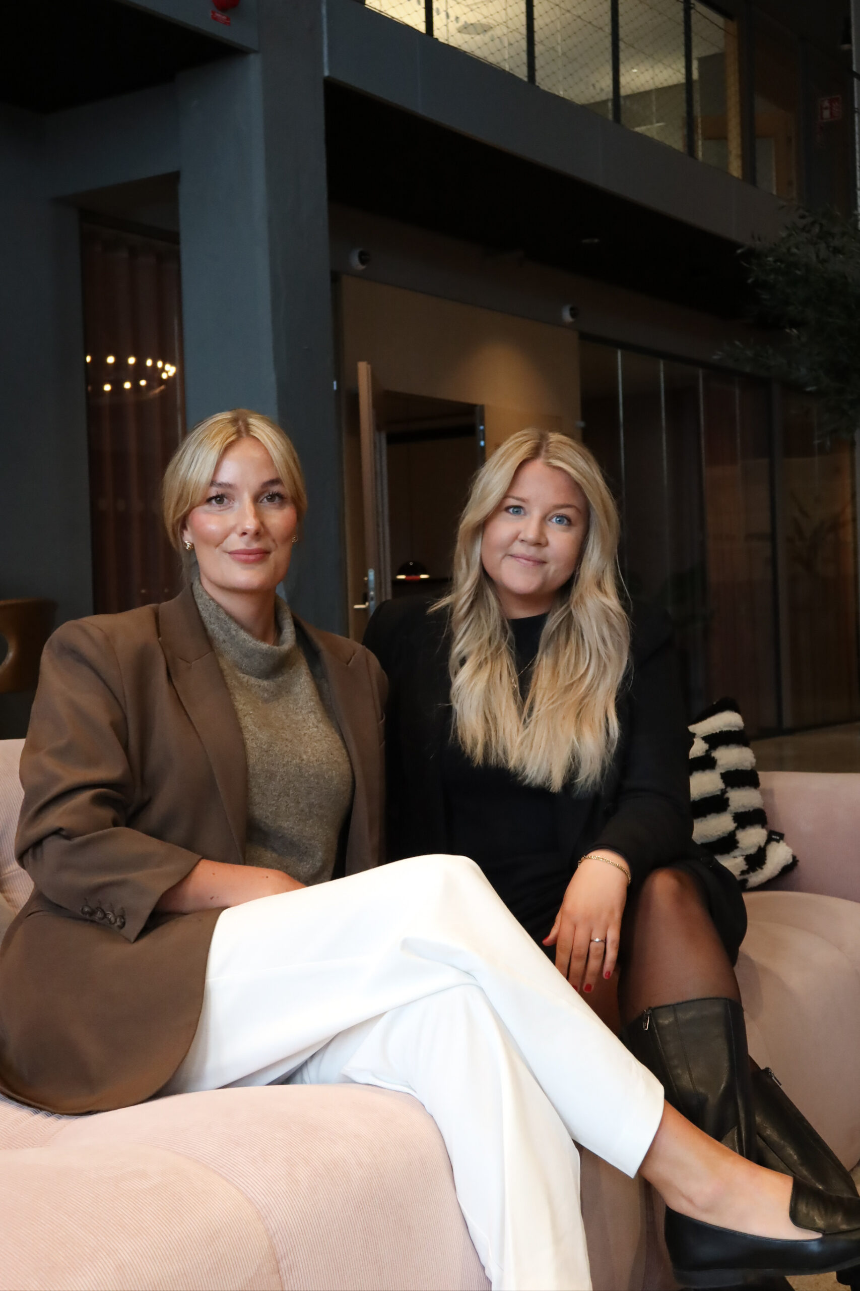 Ida Tollerud och Frida Lampe sitter i soffan och tittar in i kameran.
