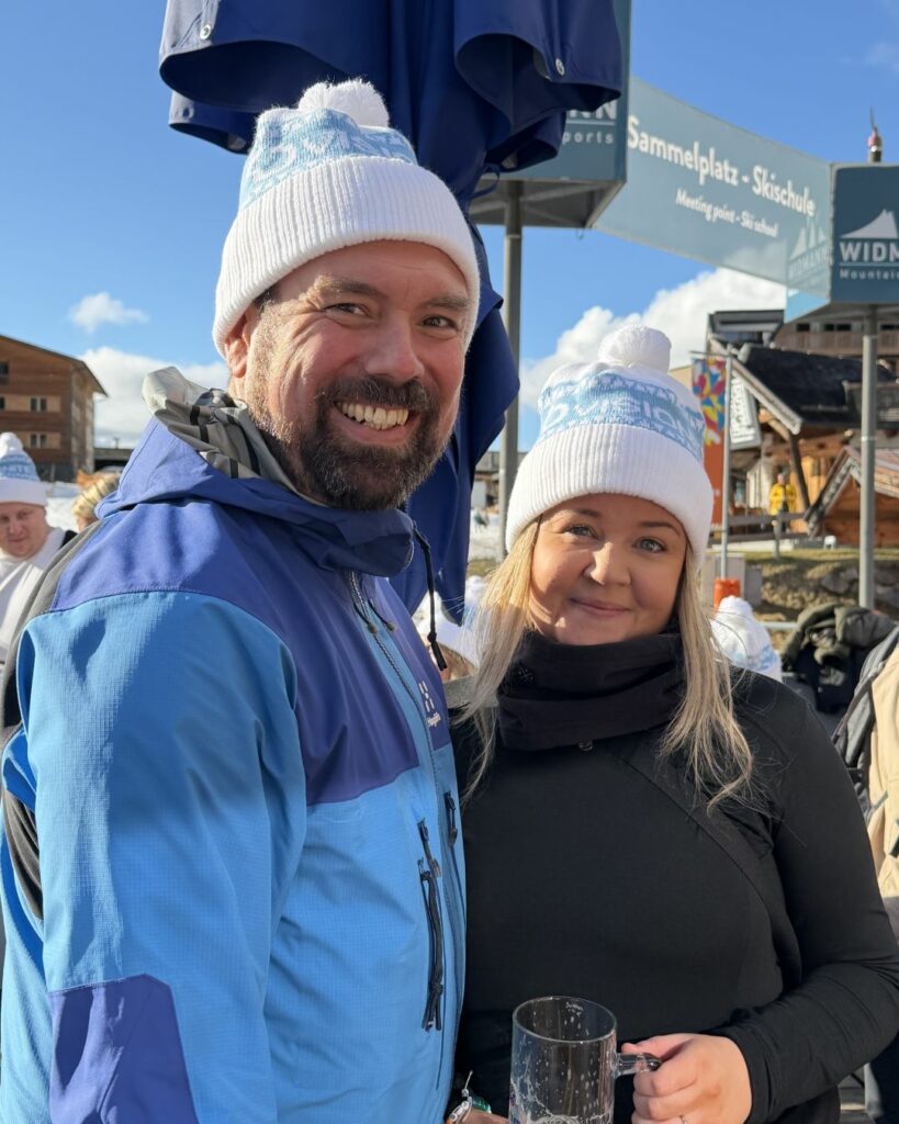 Fredrik Bardon och Frida Lampe ler och står på en uteservering i Fieberbrunn, Österrike.